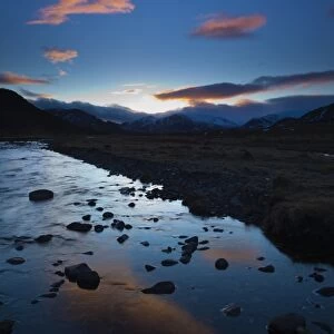 Scotland, Scottish Highlands, Cairngorms National Park. Clouds at sunset reflected upon the still waters of the River Calder running through Glen Banchor near Newtonmore and the