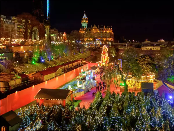 Scotland, Edinburgh, Princes Street Christmas Market. A traditional European Christmas Market located along Princes Street with the Scotts Monument and Balmoral Clock Tower in view