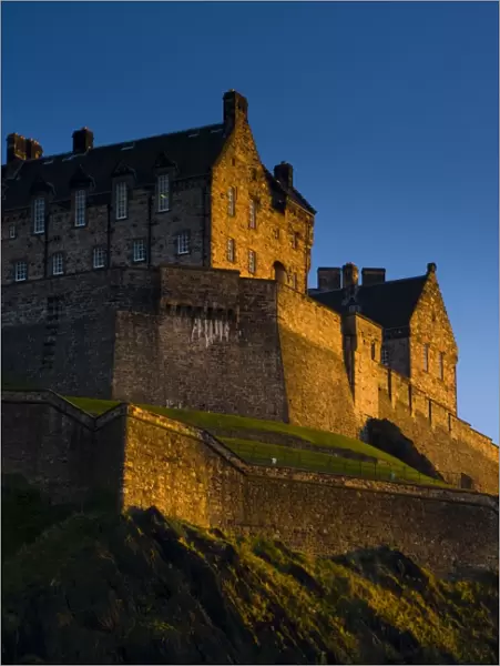 Scotland, Edinburgh, Edinburgh Castle. The last light of the setting sun illuminates Edinburgh Castle