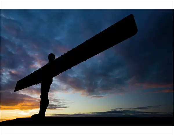 The iconic Angel of the North statue silhouetted against an atmospheric sky