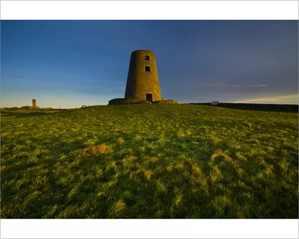 England, Tyne & Wear, Cleadon Hills. The rising sun spotlights the old mill in Windmill Field