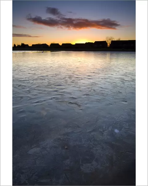 England, Tyne & Wear, Killingworth. Ice covered lake near to a residential estate in Killingworth
