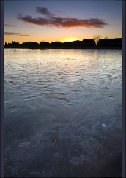 England, Tyne & Wear, Killingworth. Ice covered lake near to a residential estate in Killingworth
