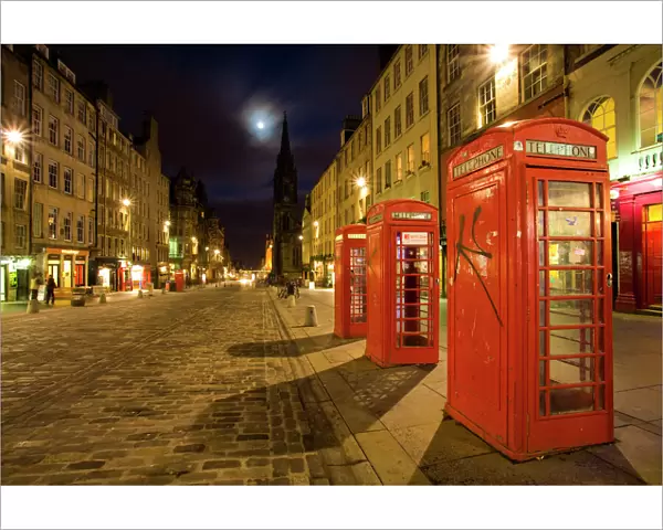 Scotland, Edinburgh, The Royal Mile. Cobbled stone road and traditional red telephone boxes in the High Street, part of the historic Royal Mile in the