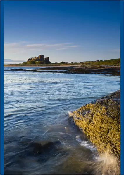 England, Northumberland, Bamburgh. Bamburgh Castle, beach and dunes viewed shortly after sunrise from