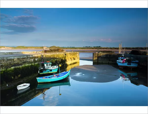 England, Northumberland, Beadnell. Boats moored within the Harbour Walls of the Beadnell Harbour - viewed at