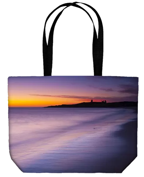England, Northumberland, Embleton Bay. A colourful display of pre-dawn colours relected upon the wet sands of Embleton Bay, overlooked by the dramatic ruins of