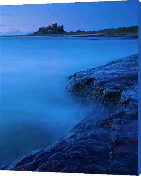 England, Northumberland, Bamburgh. Bamburgh Castle and the North Sea, viewed from Harkess Rocks