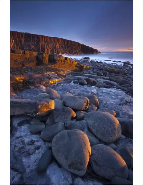 England, Northumberland, Cullernose Point. Dawn light illuminates the rocky shoreline of Cullernose Point, near the village of Craster on the Northumberland