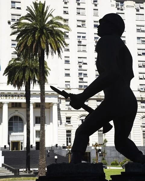 Argentina, Buenos Aires Province, Buenos Aires. Silhouted statue of a soldier outside a military building in