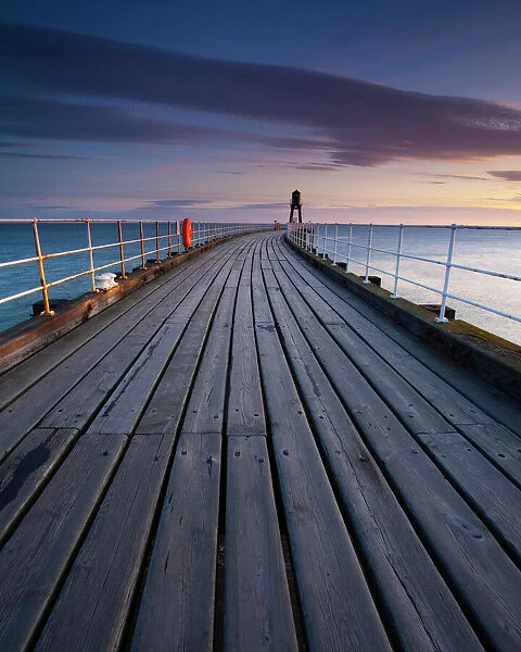 England, North Yorkshire, Whitby. One of the entrance piers of Whitby Harbour at dawn