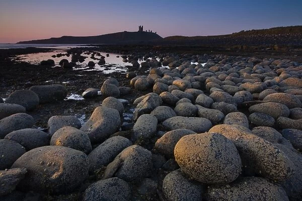 England, Northumberland, Embleton Bay. Weathered rocks dominate the low-tide shoreline of Embleton Bay