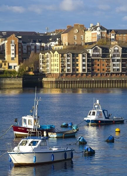 England, Tyne & Wear, North Shields. Boats moored on the River Tyne with a complex of new apartments located on the North Shields Quayside in
