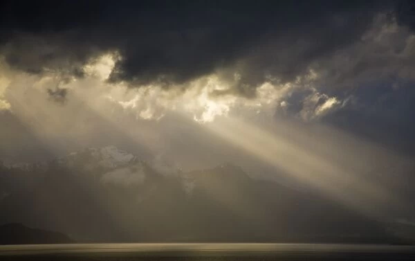 New Zealand, Southland, Fiordland National Park. Dramatic light as a storm clears from the moutain peaks surrounding Lake