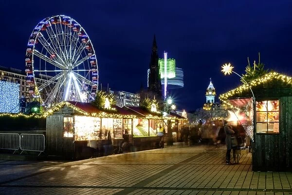 Scotland, Edinburgh, Princes Street Christmas Market. A traditional European Christmas Market located along Princes Street with the Scotts Monument and Balmoral Clock Tower in view