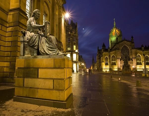 Scotland, Edinburgh, The Royal Mile. Hume statue with the St Giles Cathedral