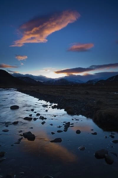 Scotland, Scottish Highlands, Cairngorms National Park. Clouds at sunset reflected upon the still waters of the River Calder running through Glen Banchor near Newtonmore and the