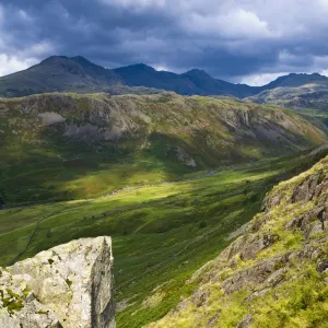 England, Cumbria, Lake District National Park. Looking along the route of the River Esk from the Hardknott Castle Roman Fort, as storms clouds gather above the countrys highest peak, Scafell Pike at 3205ft