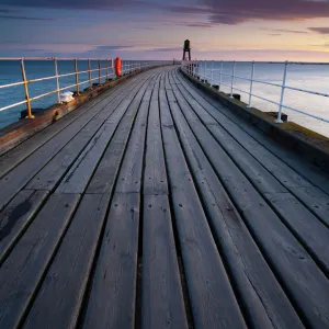 England, North Yorkshire, Whitby. One of the entrance piers of Whitby Harbour at dawn