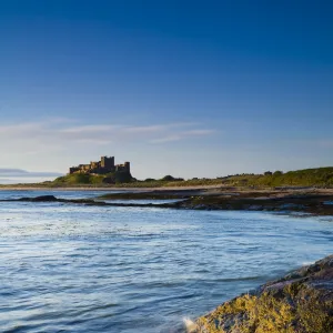 England, Northumberland, Bamburgh. Bamburgh Castle, beach and dunes viewed shortly after sunrise from