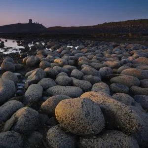 England, Northumberland, Embleton Bay. Weathered rocks dominate the low-tide shoreline of Embleton Bay