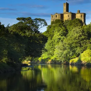 England, Northumberland, Warkworth. Warkworth Castle reflected in the still waters of the River Coquet