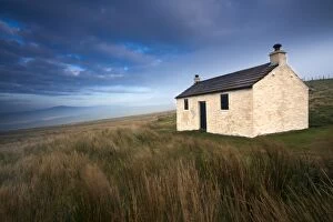 England, Cumbria, North Pennines. A small cottage located within the barren landscape of Hartside Pass near Alston