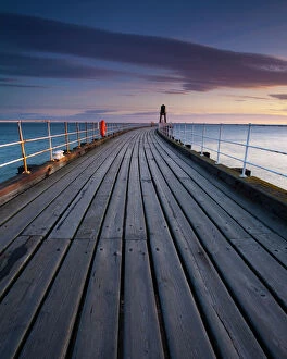 England, North Yorkshire, Whitby. One of the entrance piers of Whitby Harbour at dawn