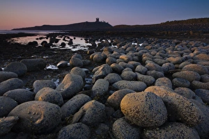 England, Northumberland, Embleton Bay. Weathered rocks dominate the low-tide shoreline of Embleton Bay