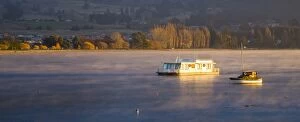 Boat Gallery: New Zealand, Otago, Lake Wanaka. The warm hues of sunset highlight the rising mist engulfing boats