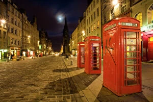 Edinburgh Illuminated Book Gallery: Scotland, Edinburgh, The Royal Mile. Cobbled stone road and traditional red telephone boxes in