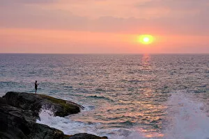 What's New: Sri Lanka, Galle District, Ahungalla. Tourist enjoys the sunset whilst fishing at Ahungalla Beach